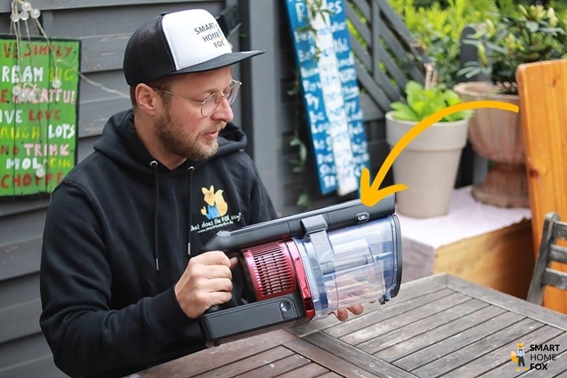 You can see the button for opening the dirt bin.